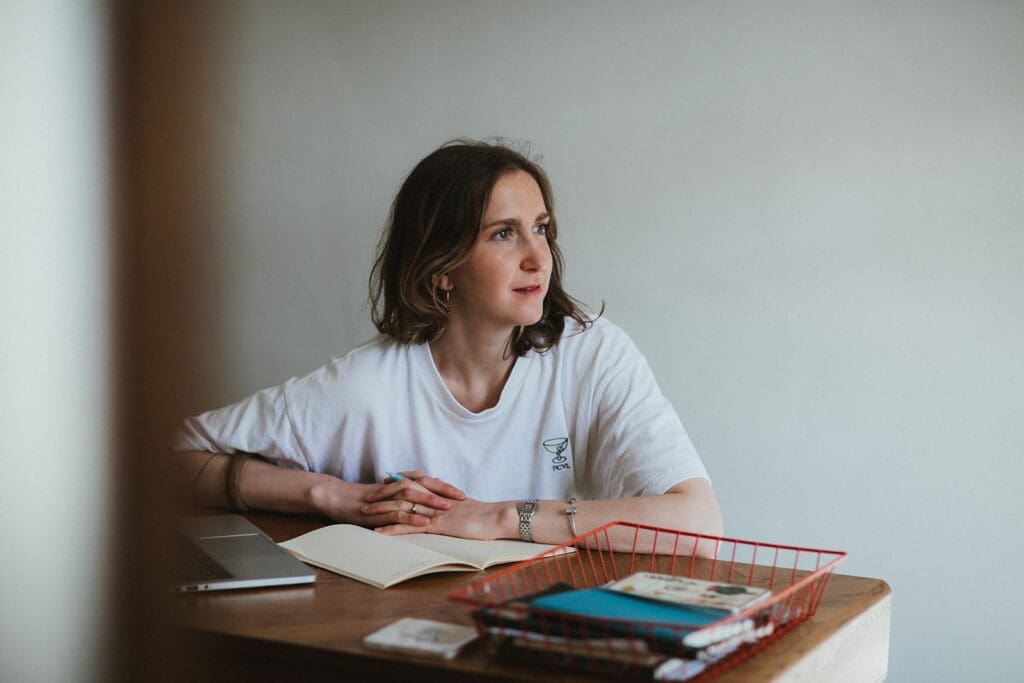 Coach and copywriter looks out of the window in her office